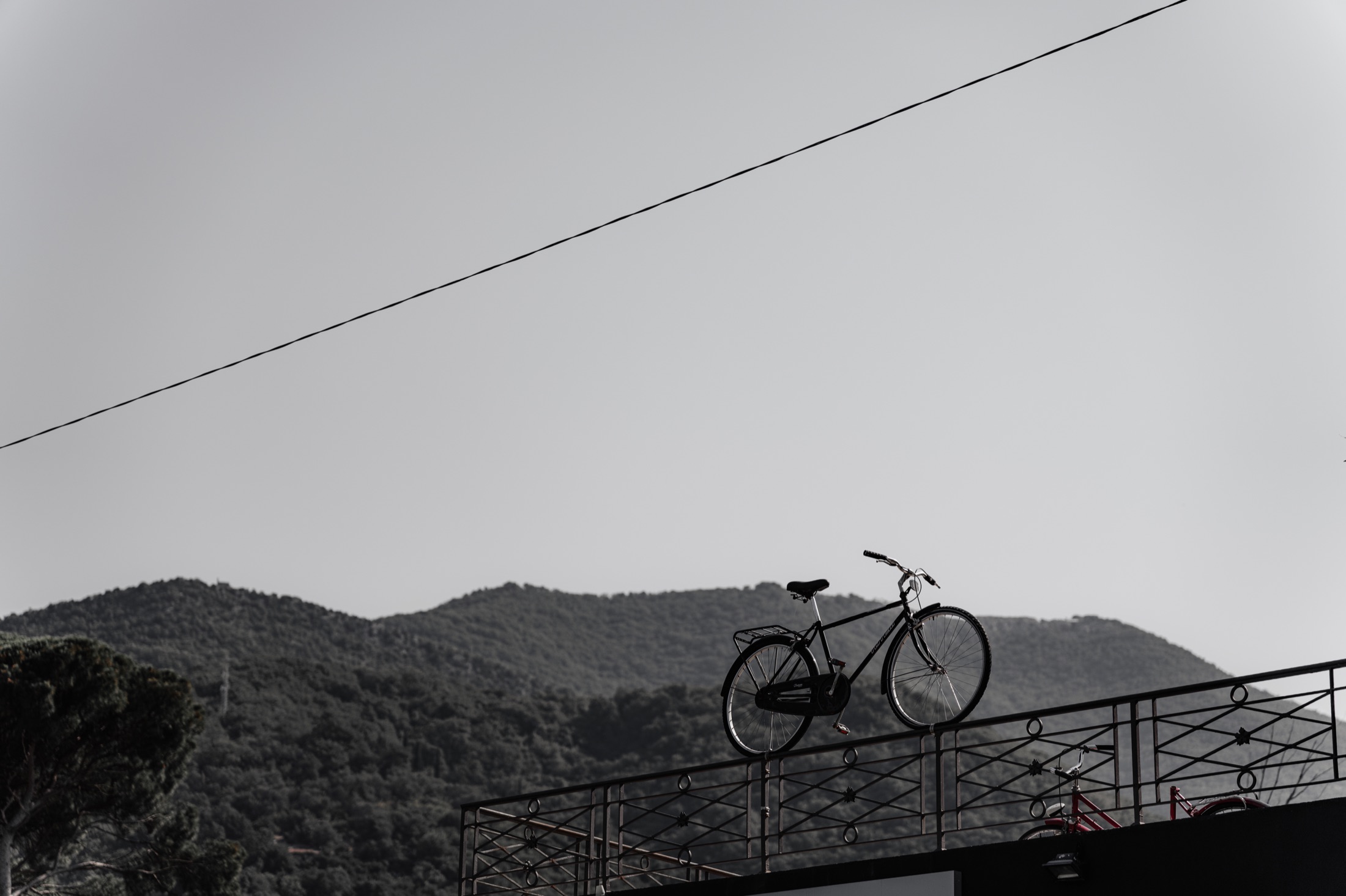 A bicycle balanced above a hillside beneath an open sky