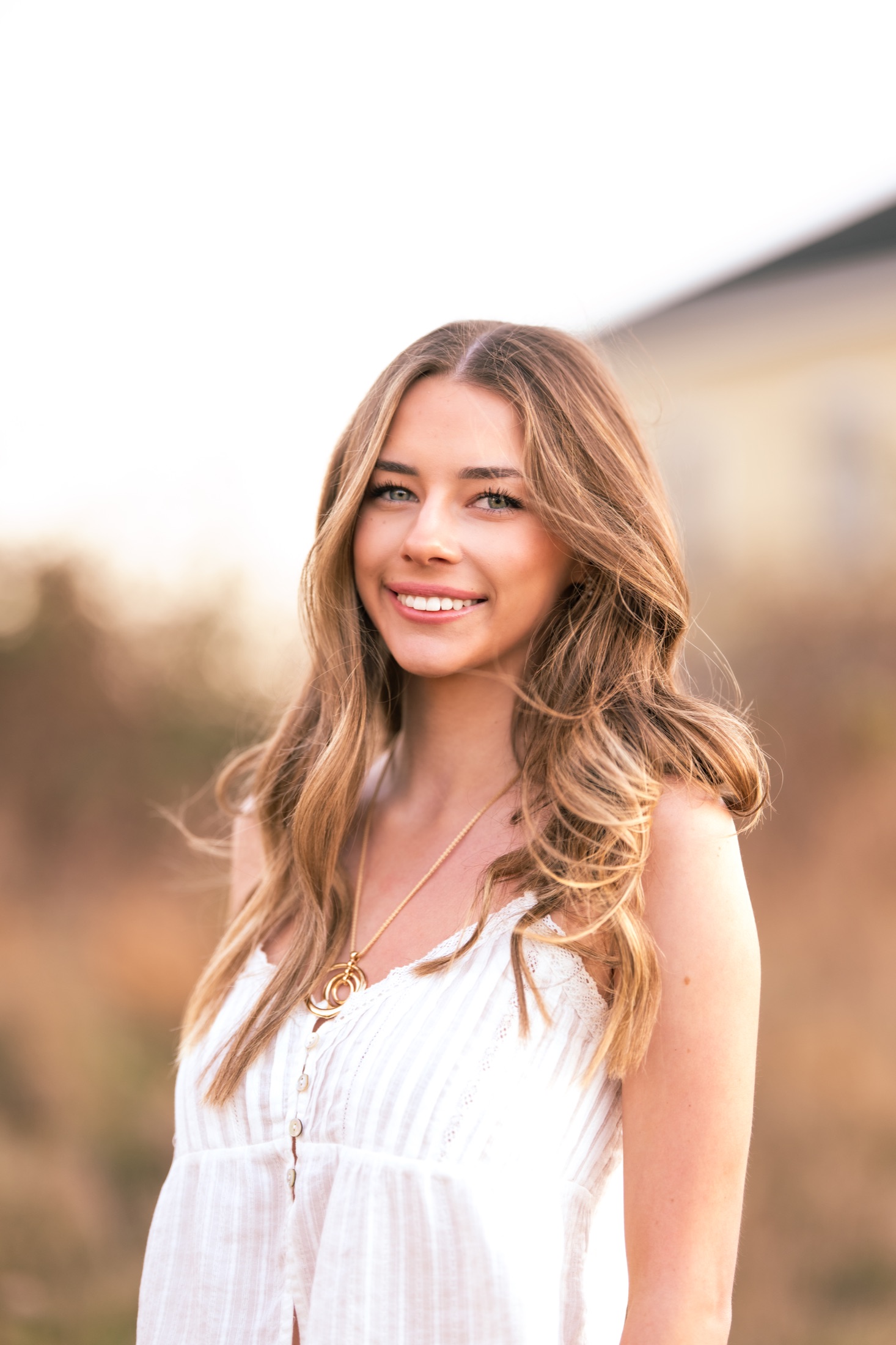Close outdoor portrait of a young woman in a white dress