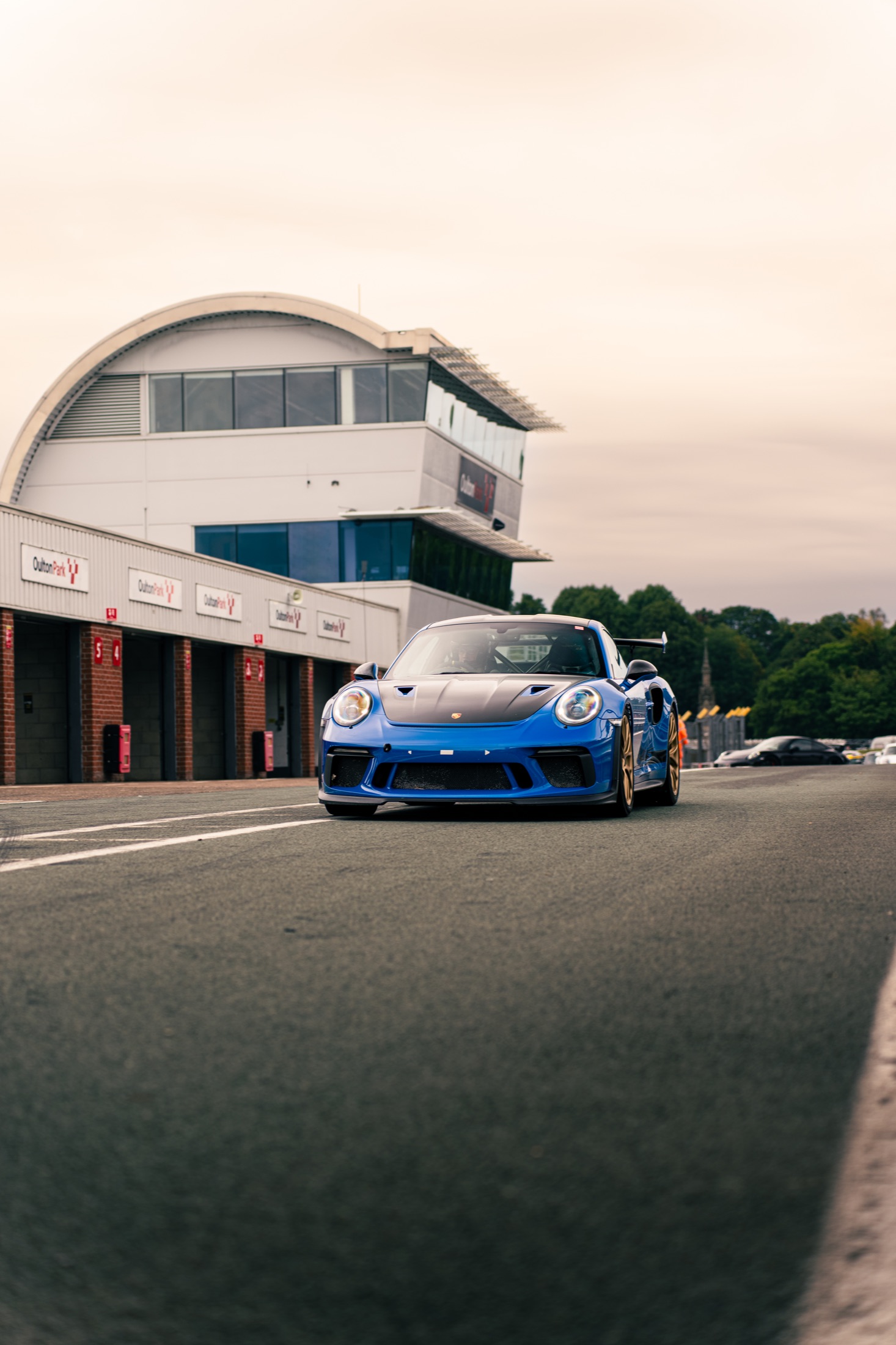 Blue Porsche GT3 moving through the Oulton Park pit lane