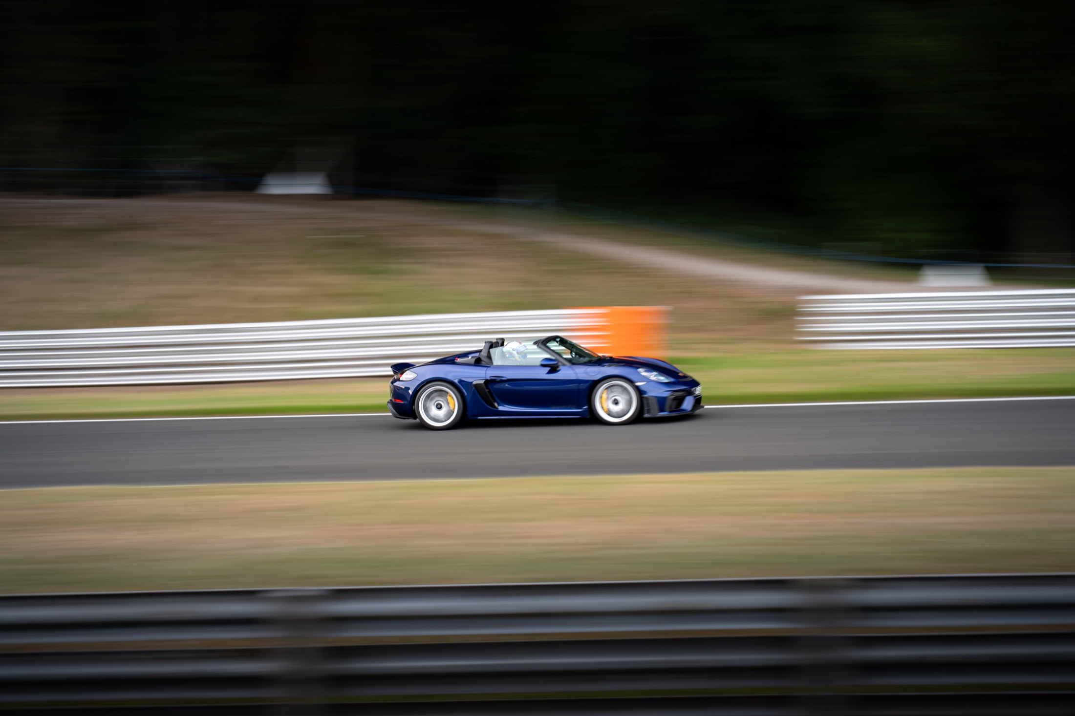 Blue Porsche photographed with a panning blur at speed