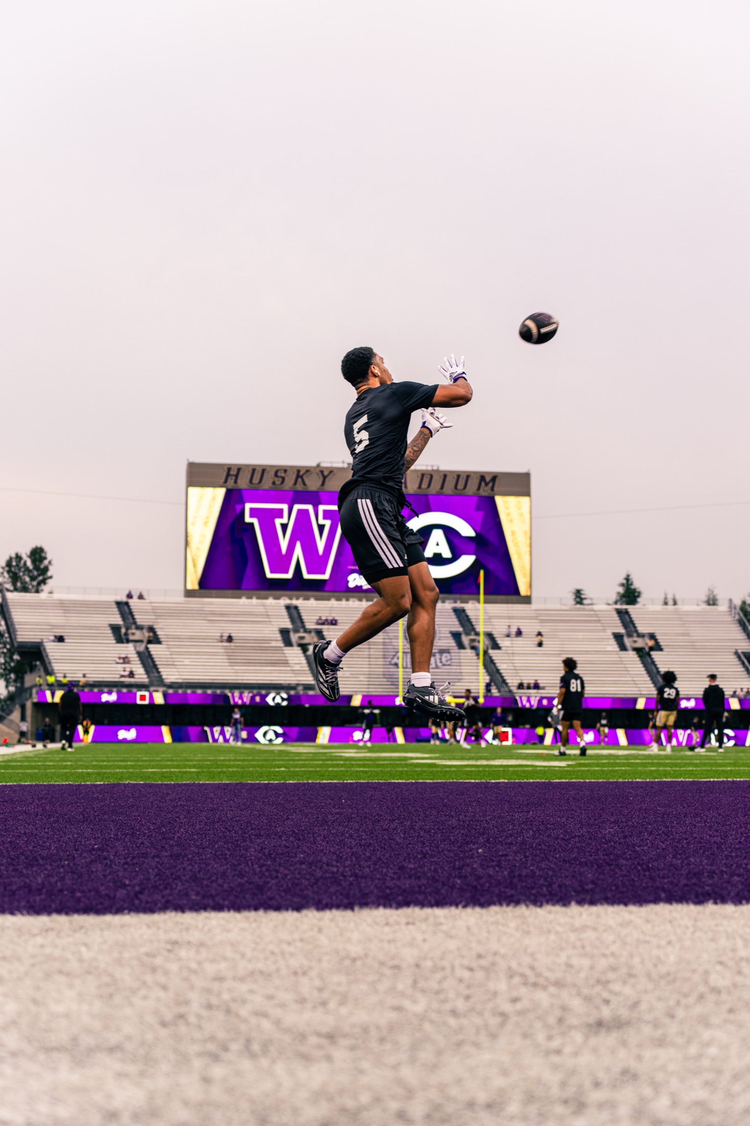 Washington receiver leaping for a warmup catch in the end zone
