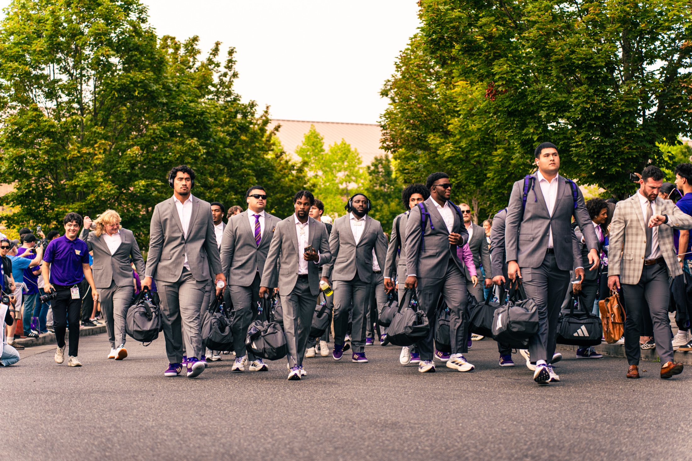 Washington football players walking together in suits on game day
