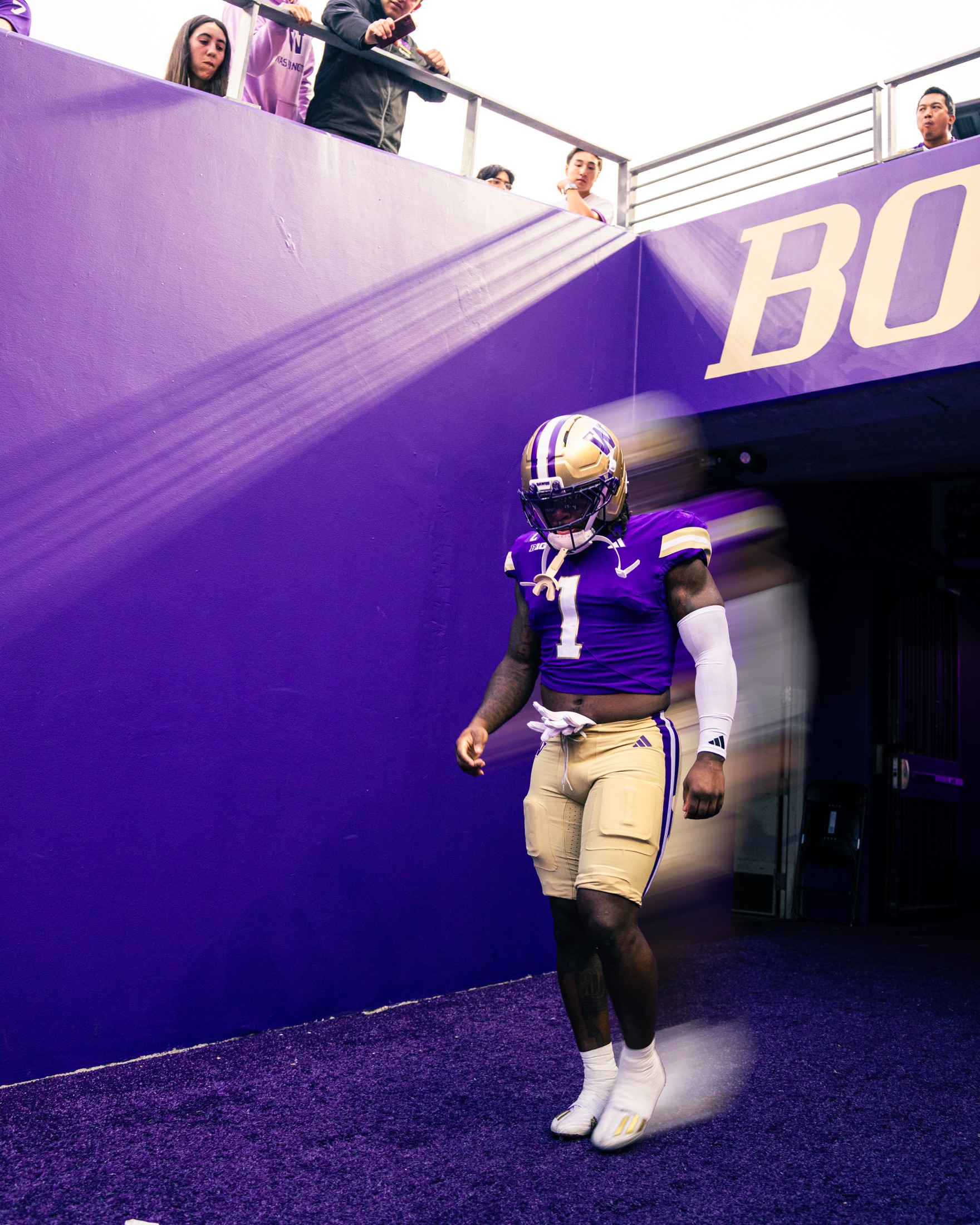 Washington player number one emerging from the purple stadium tunnel