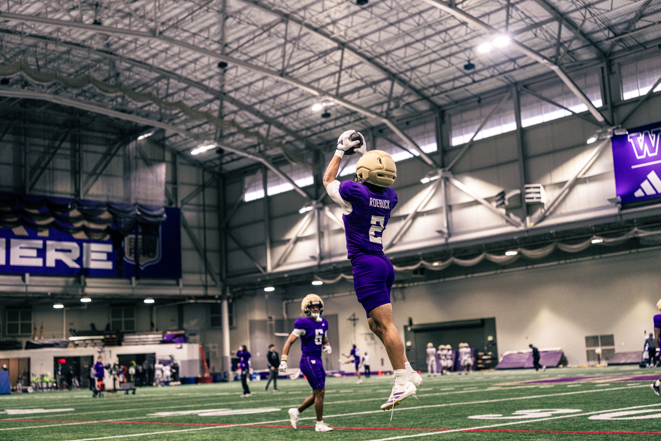Washington receiver jumping for a catch during indoor practice